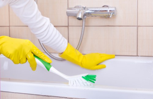 Cleaner wiping commercial windows in Kingston with attention to detail